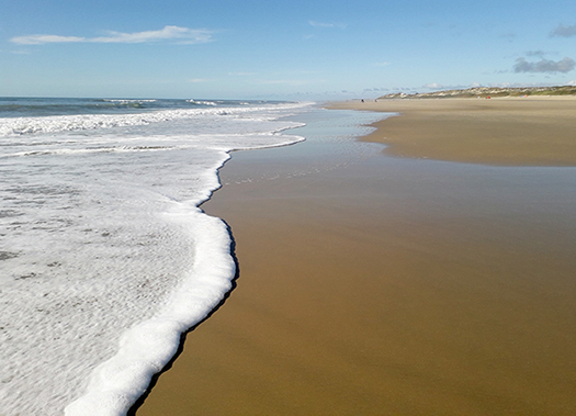 Onde sulla battigia. Scatto della riva dell'oceano Atlantico